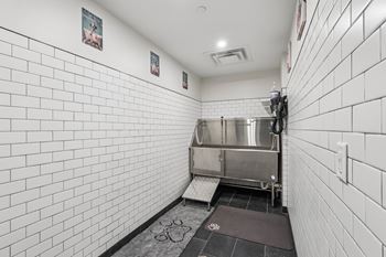 A white tiled bathroom with a sink and a toilet.